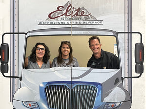 Cardboard cutout of a truck with 'Elite Brands' logo, featuring Brian & Melissa inside.